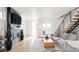 Bright living room features a fireplace, flatscreen television, and modern staircase to the second level at 2685 S Acoma St, Denver, CO 80223
