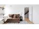 Comfortable living room with a brown sofa, modern rug, and an open staircase with metal railings at 2685 S Acoma St, Denver, CO 80223