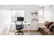Home office with white desk, ergonomic chair, floating shelves, and a comfortable brown sofa at 2685 S Acoma St, Denver, CO 80223