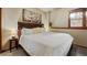 Relaxing bedroom featuring a large bed with white linens, a decorative headboard, and a window view at 43 Snowflake Dr # D7, Breckenridge, CO 80424