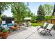 Inviting back patio featuring modern furniture, an outdoor dining set, and lush landscaping, perfect for relaxing at 7695 S Sheridan Ct, Littleton, CO 80128