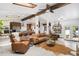 Open concept living room and kitchen with wood beam accents, skylights and tiled floor at 7695 S Sheridan Ct, Littleton, CO 80128