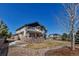 Wide view of home's back exterior showing a stone patio and well-manicured lawn at 6236 S Robertsdale Ct, Aurora, CO 80016