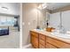 Well-lit bathroom featuring dual sinks, storage, and view to connecting bedroom at 6236 S Robertsdale Ct, Aurora, CO 80016