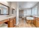Well-lit bathroom featuring a soaking tub, walk-in shower, and dual vanities at 6236 S Robertsdale Ct, Aurora, CO 80016