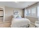 Bedroom features plush bedding and a bright shuttered window at 6236 S Robertsdale Ct, Aurora, CO 80016