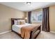 Bedroom featuring a plush bed, natural light from shuttered window, and neutral decor at 6236 S Robertsdale Ct, Aurora, CO 80016