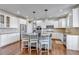 Bright kitchen features white cabinets, stainless steel appliances, and a center island with pendant lighting at 6236 S Robertsdale Ct, Aurora, CO 80016