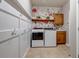 Functional laundry room with washer, dryer, storage, and floral wallpaper at 6236 S Robertsdale Ct, Aurora, CO 80016