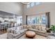 Bright living room features a large sofa, hardwood floors, and kitchen view at 6236 S Robertsdale Ct, Aurora, CO 80016