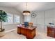 Bright home office with a large wooden desk, decorative wall paneling, and natural light at 6236 S Robertsdale Ct, Aurora, CO 80016