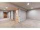 Finished basement space with neutral carpet, lighting, and doorways leading to additional rooms and a bathroom at 13241 Heart Lake Way, Broomfield, CO 80020