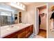 Bathroom with a double sink vanity, a large mirror, and a shower with tile and a glass door at 13241 Heart Lake Way, Broomfield, CO 80020