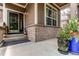 Inviting porch featuring brick accents, potted plants, and a charming entryway at 13241 Heart Lake Way, Broomfield, CO 80020