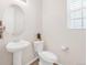 Bright powder room with pedestal sink and oval mirror provides a convenient space for guests at 5032 S Valdai Way, Aurora, CO 80015