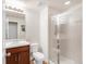 Bright bathroom featuring a glass-enclosed shower, modern vanity with sink, toilet, and neutral tiling for a clean look at 5032 S Valdai Way, Aurora, CO 80015