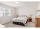 Cozy bedroom with plush carpeting, bedside tables, and a large window for natural light at 5032 S Valdai Way, Aurora, CO 80015