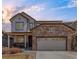 Charming two-story home with a stone facade, a covered front porch, and a well-manicured front yard creating curb appeal at 5032 S Valdai Way, Aurora, CO 80015