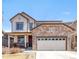 Charming two-story home with a stone facade, covered porch, and well-maintained landscaping at 5032 S Valdai Way, Aurora, CO 80015