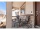 Inviting covered front porch with chairs, a small table, and stone accents at 5032 S Valdai Way, Aurora, CO 80015