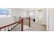 Second floor hallway featuring wood railing, carpeted floor, and access to laundry room at 5032 S Valdai Way, Aurora, CO 80015