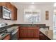 Cozy kitchen with stainless steel appliances, dark wood cabinets and granite countertops at 5032 S Valdai Way, Aurora, CO 80015