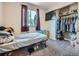 Cozy bedroom featuring a window, TV, closet with hanging clothes, and carpeted floors at 15642 E Eldorado Dr, Aurora, CO 80013