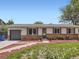 Charming single-story home with brick accents, landscaped front yard, and gray-toned garage door at 15642 E Eldorado Dr, Aurora, CO 80013