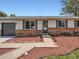 Well-maintained home featuring a brick-accented facade, landscaped yard with rock cover, and a long driveway at 15642 E Eldorado Dr, Aurora, CO 80013