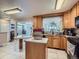 Light-filled kitchen with light wood cabinets, granite countertops, and an island with breakfast bar at 15642 E Eldorado Dr, Aurora, CO 80013