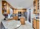 Bright kitchen features granite countertops, wood cabinets, stainless steel appliances, and tile floors at 15642 E Eldorado Dr, Aurora, CO 80013
