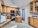 Spacious kitchen features granite countertops, wooden cabinets, stainless steel appliances, and tile floors at 15642 E Eldorado Dr, Aurora, CO 80013