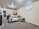 Finished basement rec room featuring carpeted floors, seating area, mini refrigerator, and a small window at 15642 E Eldorado Dr, Aurora, CO 80013