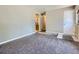 Neutral toned living room with plush carpet, leading to the kitchen, and a view of a stainless fridge at 15642 E Eldorado Dr, Aurora, CO 80013
