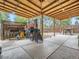 Covered outdoor patio with a concrete base, wood beam roof, and outdoor cooking area and seating at 15642 E Eldorado Dr, Aurora, CO 80013