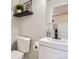 Modern half bath features a sleek vanity, black faucet, decorative shelf, and a stylish mirror at 885 Kenton St, Aurora, CO 80010