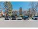 The exterior showcases well-maintained townhomes with stone chimneys and ample parking spaces at 9671 W Chatfield Ave # B, Littleton, CO 80128