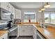 Beautiful kitchen featuring stainless steel appliances and a butcher block countertop at 9671 W Chatfield Ave # B, Littleton, CO 80128