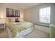 Comfortable bedroom with a large window, green bedding, and a painted accent chest at 27790 E 9Th Pl, Aurora, CO 80018
