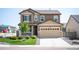 Charming two-story home featuring a two-car garage, covered porch, and well-manicured lawn at 27790 E 9Th Pl, Aurora, CO 80018