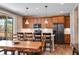 A spacious kitchen featuring wood floors, brown cabinets, stainless steel appliances, and a large island with pendant lighting at 27790 E 9Th Pl, Aurora, CO 80018