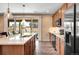 This kitchen features wood floors and cabinets, stainless steel appliances, a large island, and access to the outdoor living area at 27790 E 9Th Pl, Aurora, CO 80018
