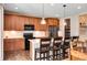 Modern kitchen boasts wood cabinets, stainless steel appliances, a subway tile backsplash, and an island with barstool seating at 27790 E 9Th Pl, Aurora, CO 80018