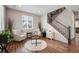 Cozy living room with hardwood floors, bright windows, neutral walls, and staircase at 27790 E 9Th Pl, Aurora, CO 80018