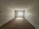 Bedroom featuring neutral carpet, window with blinds and a wall mounted air conditioner at 9650 Huron St # 23, Thornton, CO 80260