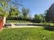 Outdoor pool closed for the season in backyard surrounded by green grass and trees at 9650 Huron St # 23, Thornton, CO 80260