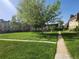 Apartment complex features green common area with mature trees and walking path at 9650 Huron St # 23, Thornton, CO 80260