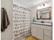 Bright bathroom with a charming bird-themed shower curtain, framed mirror, and white vanity at 1164 English Sparrow Trl, Highlands Ranch, CO 80129