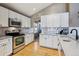 Bright kitchen with white cabinets, stainless steel appliances, modern countertops, and hardwood flooring at 1164 English Sparrow Trl, Highlands Ranch, CO 80129