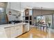 Open-concept living room and dining area with hardwood floors, large windows, a fireplace, and a kitchen island at 1164 English Sparrow Trl, Highlands Ranch, CO 80129